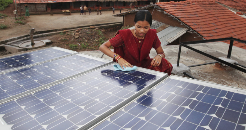 A woman is seen installing a solar panel in India