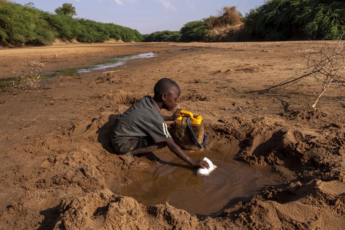 Child collects water from a muddy well.
