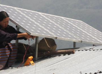 Woman mounting rooftop solar panels