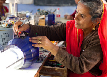 A woman works on a solar lantern. 