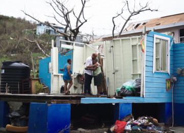 UN Climate Change Executive Secretary Simon Stiell comforts a neighbour near his grandmother’s home in Carriacou.