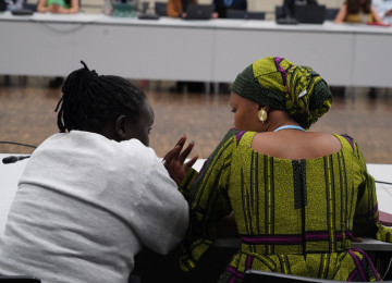 Two participants talk during the June Climate Meetings 2024 in Bonn.