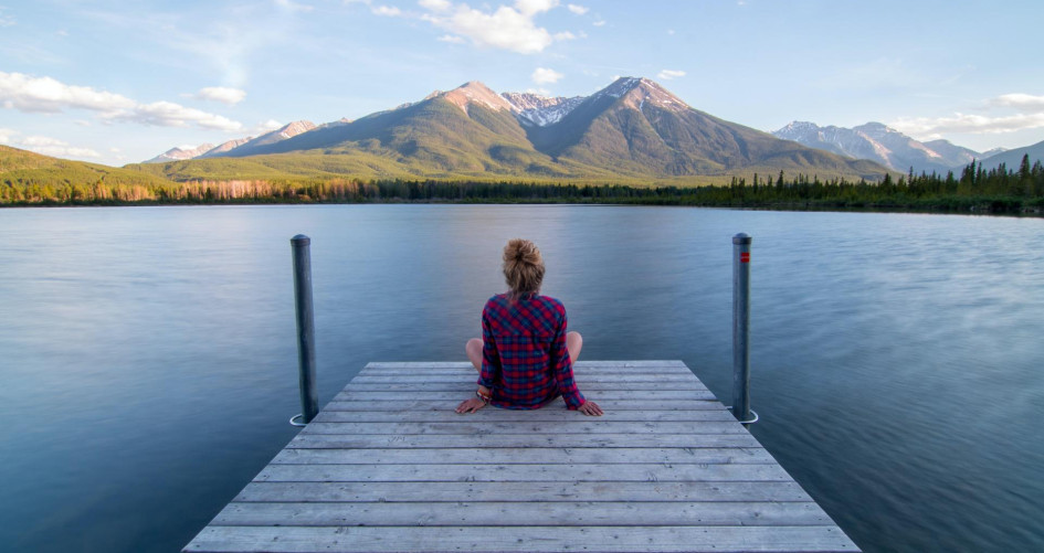 Woman contemplating nature sitting at the end of a pontoon