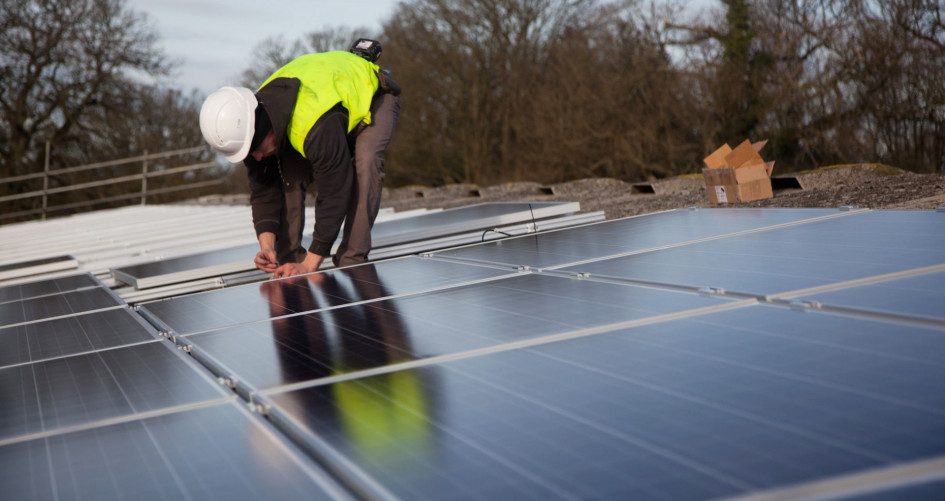 Andy Tyrrell and Jake Beautyman install solar panels on a barn roof on Grange farm, near Balcombe