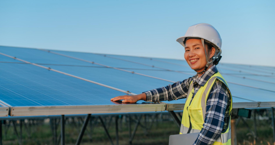 A young woman inspects solar panels. 
