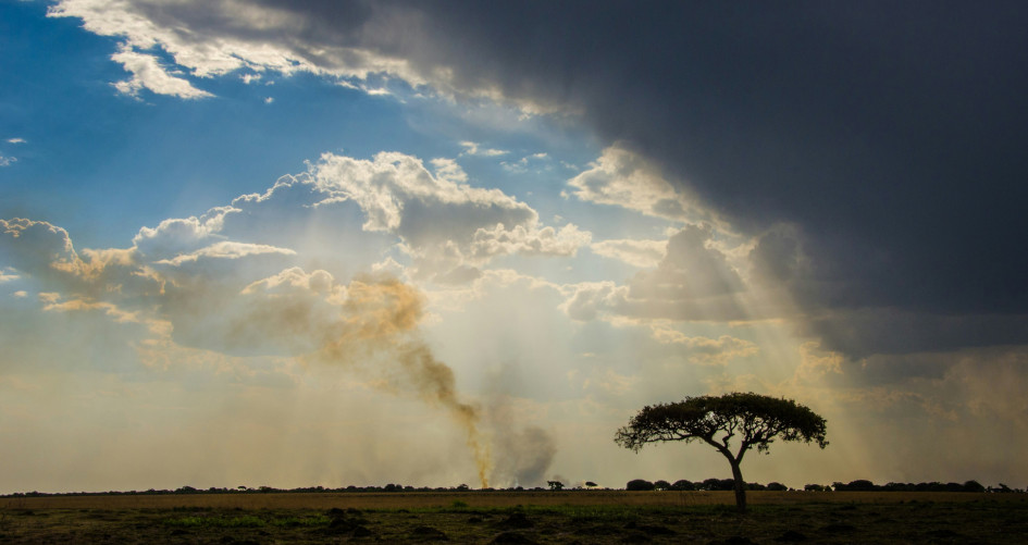 Rainclouds and fire over landscape in Zambia, Africa.