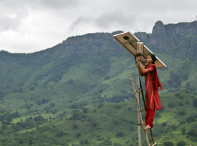 Girl mounting solar panel in India