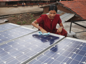 A woman is seen installing a solar panel in India