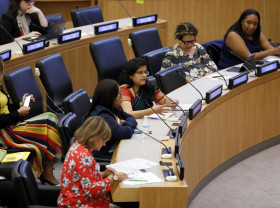 Women talking and listening at a climate change conference.