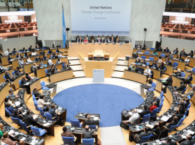 People attending a climate change conference gather in a large plenary room