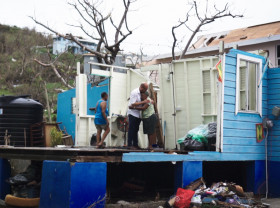 UN Climate Change Executive Secretary Simon Stiell comforts a neighbour near his grandmother’s home in Carriacou.