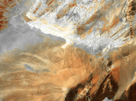 Barren ridges and fragmented mountains (lower right) border a vast expanse of arid plains etched with a complex system of dry streambeds.