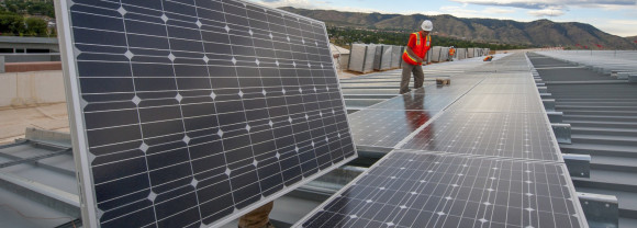 Two men install solar on a roof.